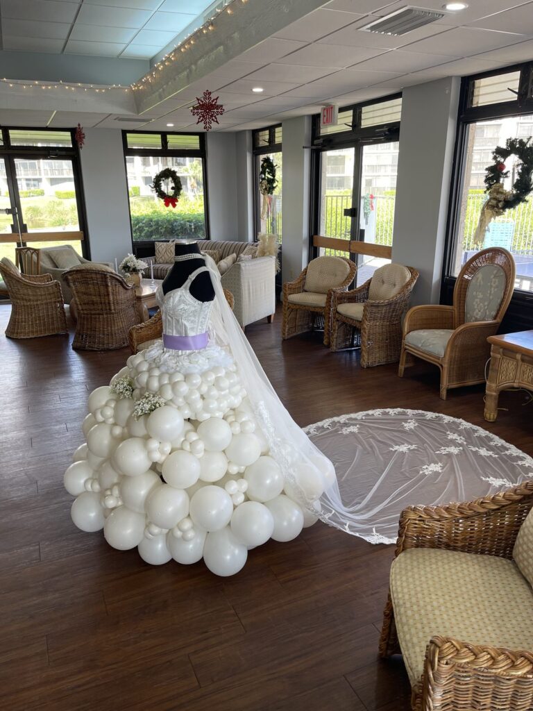 Balloon wedding gown sculpture with a long lace veil displayed at a bridal shower venue