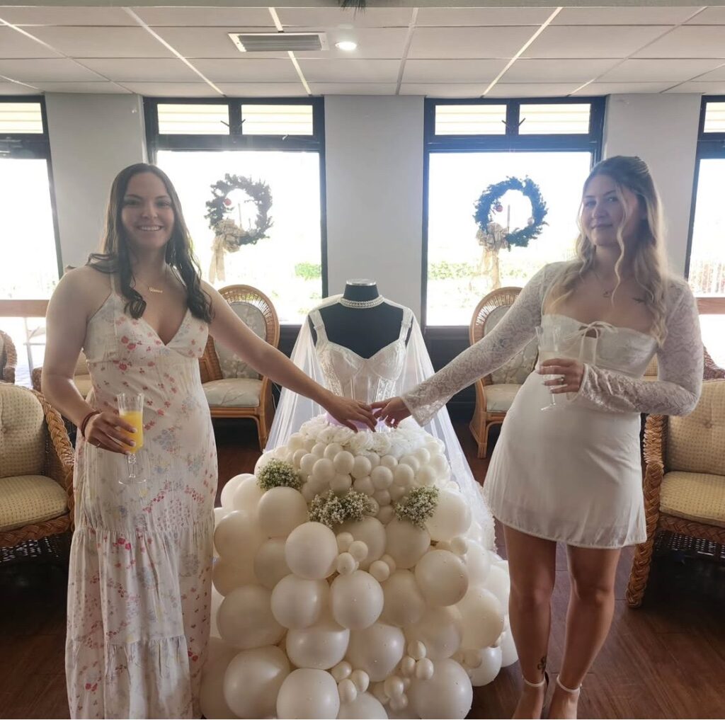 Bridal shower guests posing beside a balloon wedding gown sculpture