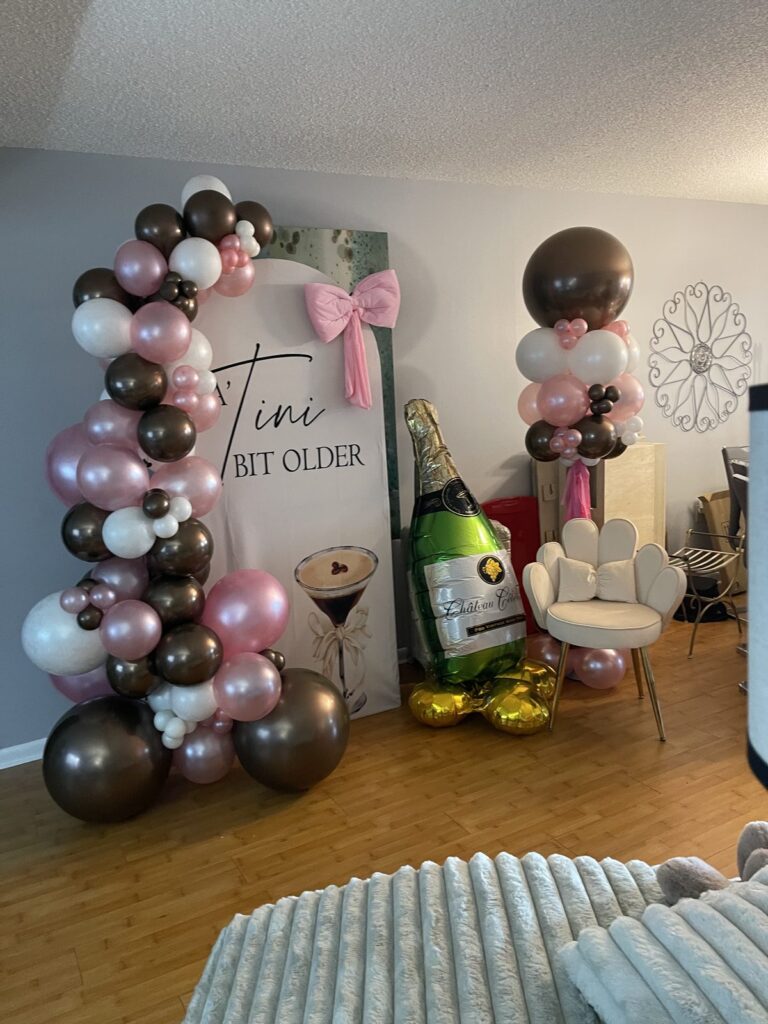 Chocolate, blush and rose gold balloon garland with a giant champagne bottle balloon