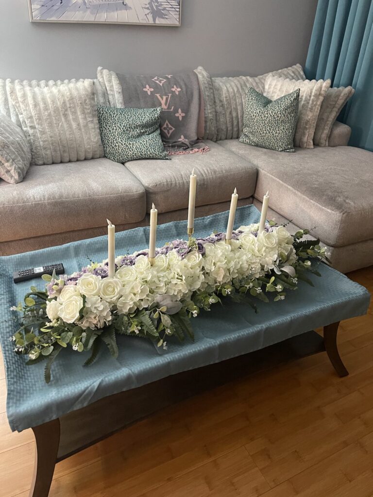 White floral and greenery centerpiece with taper candles