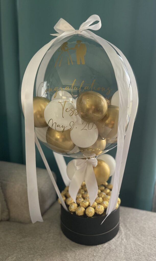 Hot air balloon style gift in white and gold with a ribbon bow