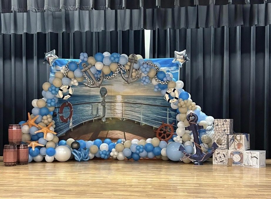 Nautical themed balloon backdrop in blue and sand tones with anchors and starfish