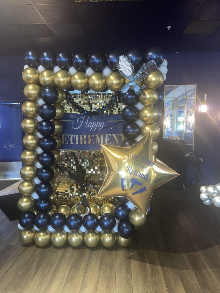 Navy and gold balloon frame around a Happy Retirement sign with a gold star