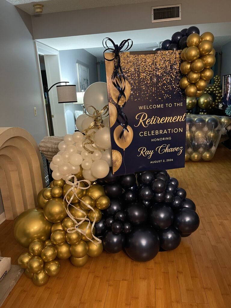 Navy, gold and ivory balloon garland framing a retirement celebration welcome sign